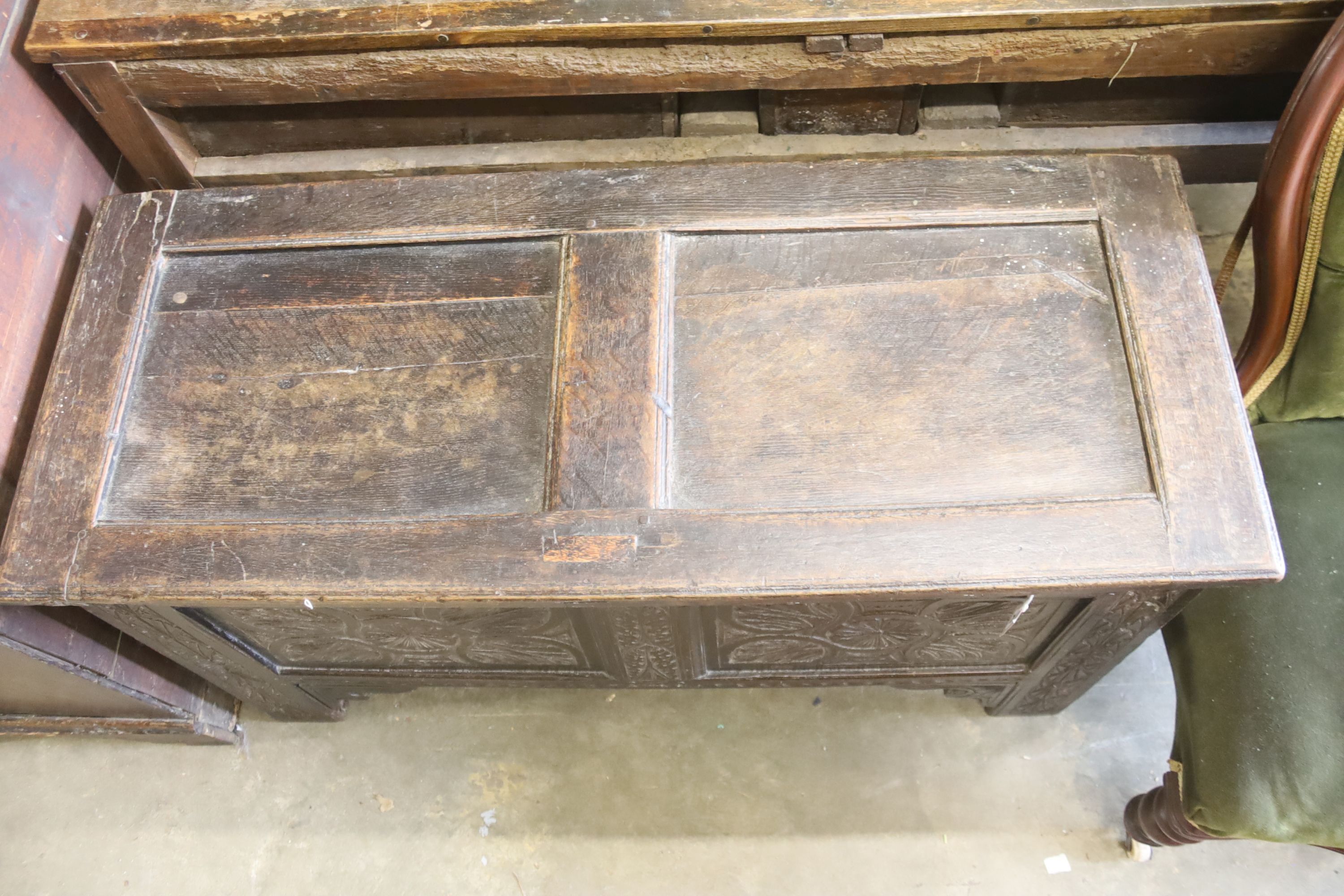 An 18th century oak coffer, later carved, length 116cm, depth 46cm, height 62cm